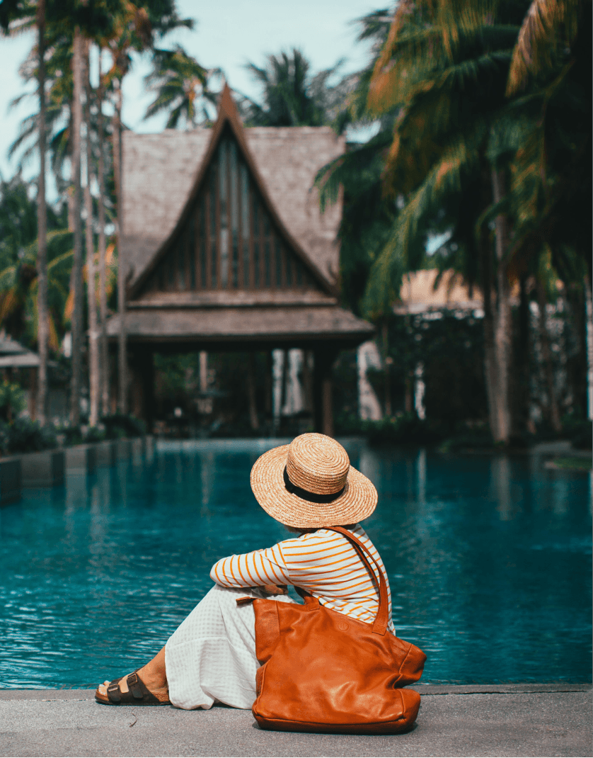 Traveler relaxing by a tropical pool